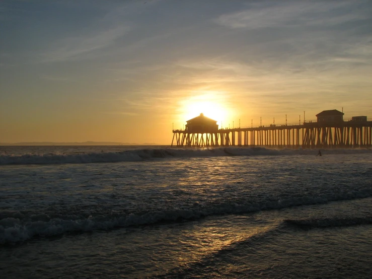 a sunset over the ocean at a pier