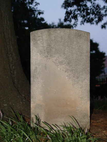 a cement monument placed next to a tree