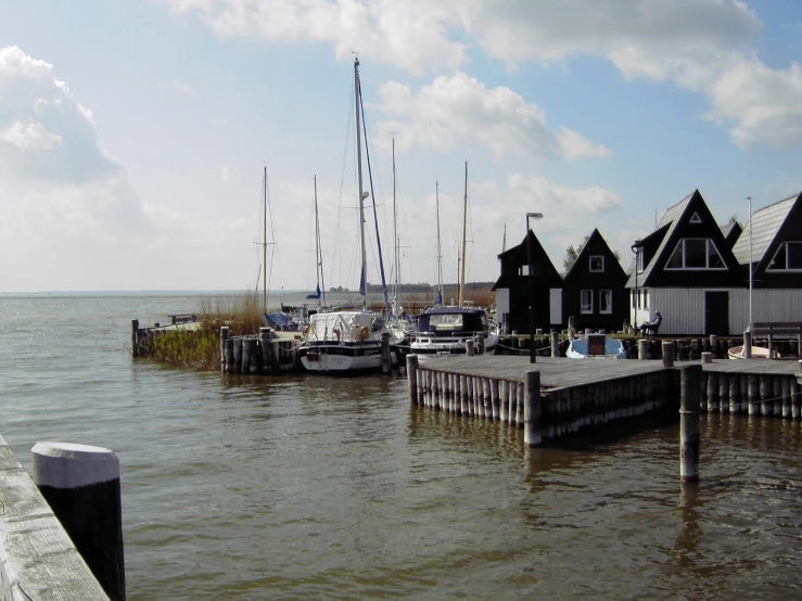 several boats are parked on the water next to houses