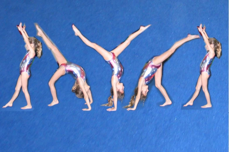 three acrobatics in pink, silver and blue doing handstand in front of a blue backdrop