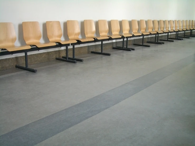 an empty row of chairs is facing a wall