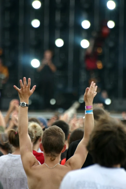 a large group of people with their hands in the air