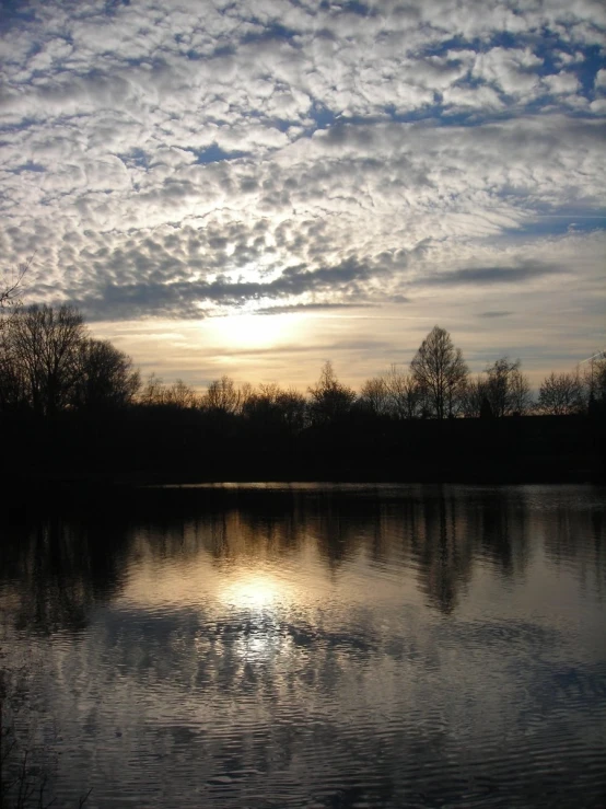 a lake with some water and the sun reflecting off of it