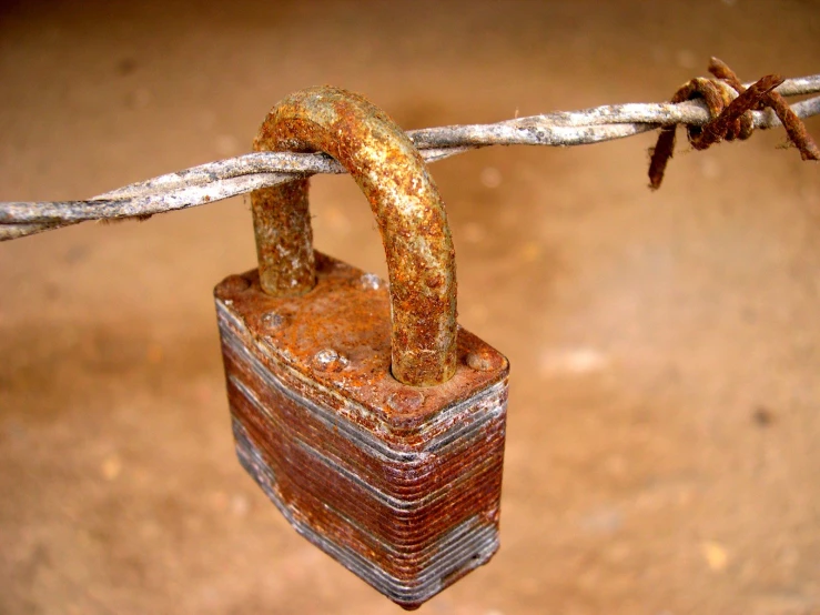 a rusty padlock  to a rusty barb wire