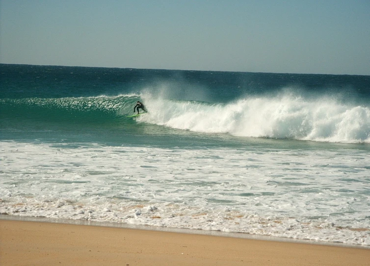 a man riding a wave on top of a surfboard