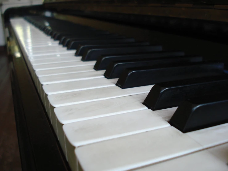 the top of an open white piano with black keys