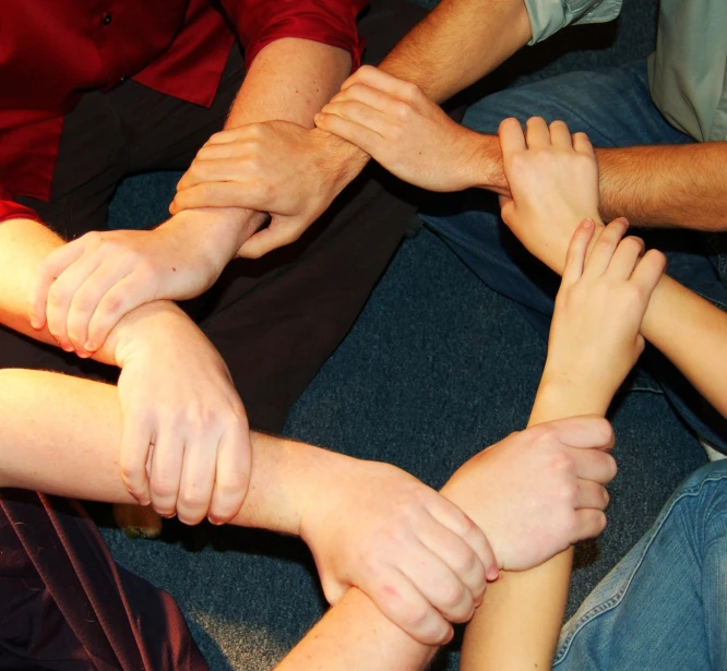 a group of people are holding their hands together