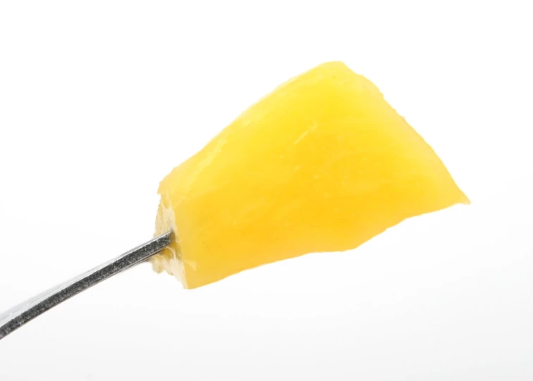 the spoon has a large yellow candy on it