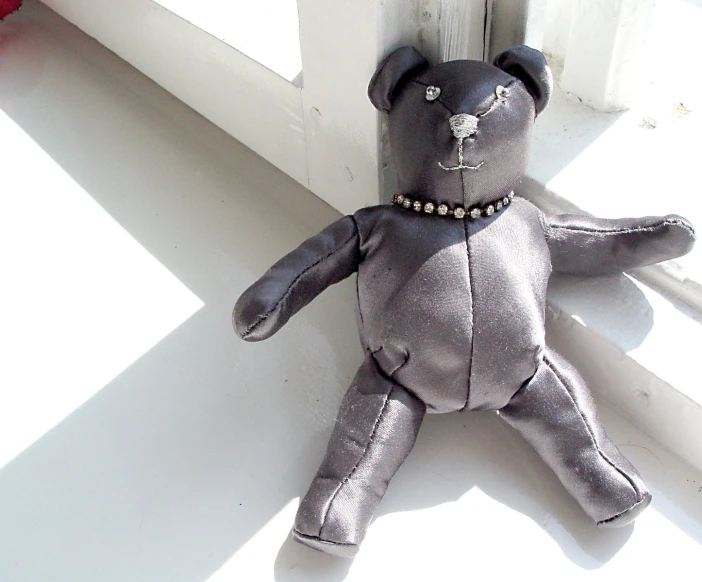 a black teddy bear that is laying down