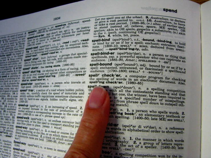 a hand touching a piece of a book with black lettering