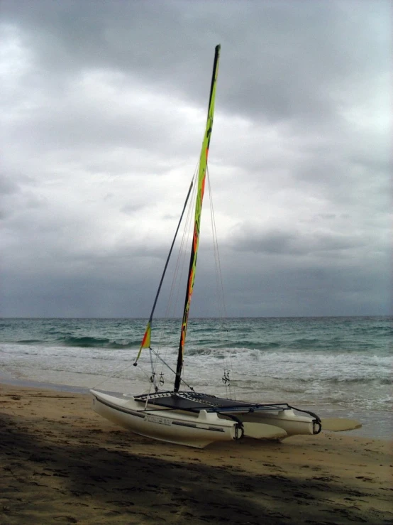 an outrigger sailing in the ocean with it's sail missing