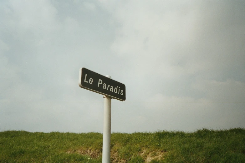 the road sign is in french on the side of the hill