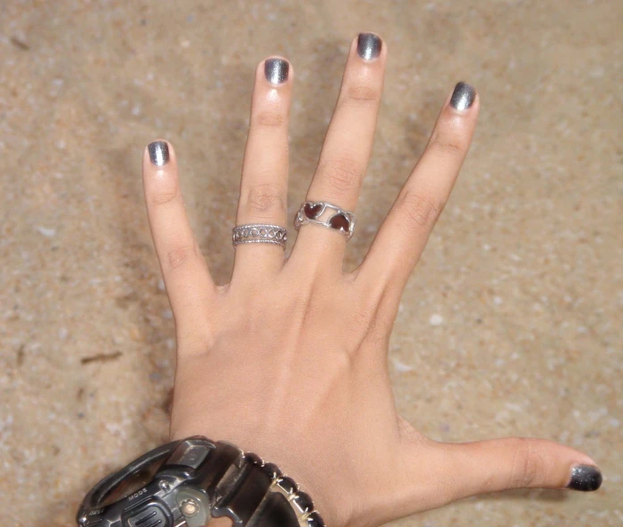 a person holding their hand up with different nail colors