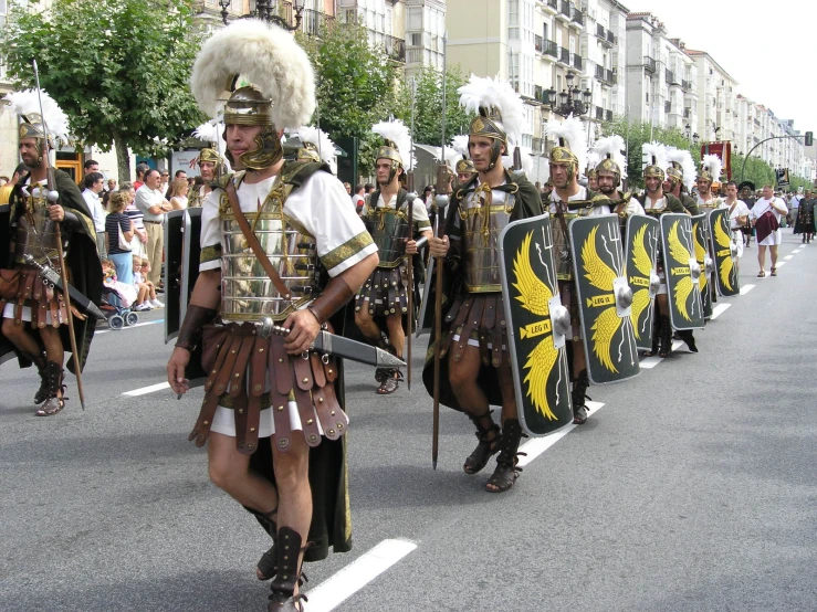 people wearing roman armor are walking down the street