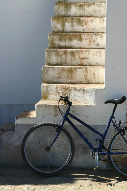 a bicycle rests against a building on the side walk