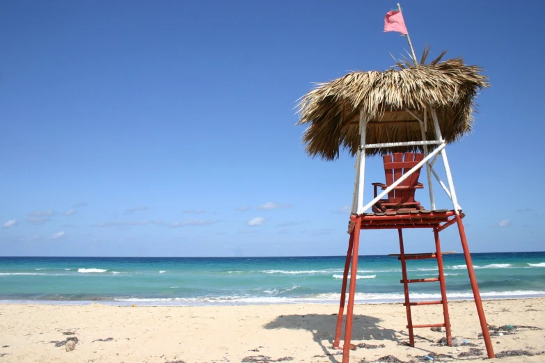 a lifeguards chair that has a small flag on it