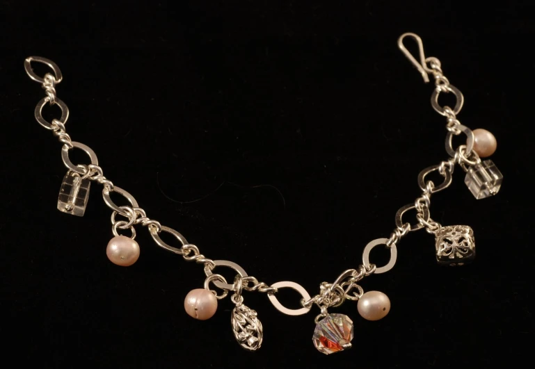 an antique style necklace with charms and stones on it