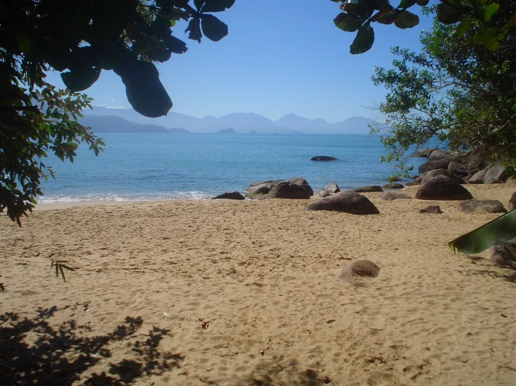 a beach that is covered in sand and rocks