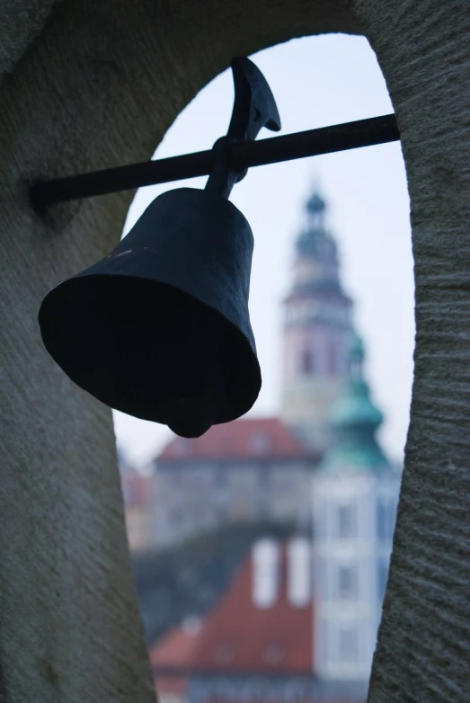 a bell hanging off of the side of a wall