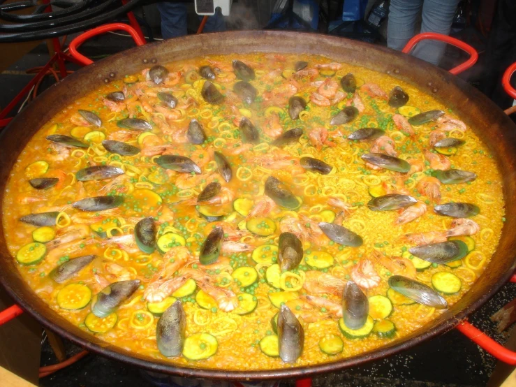 a large pan full of vegetables and food is set on a stove