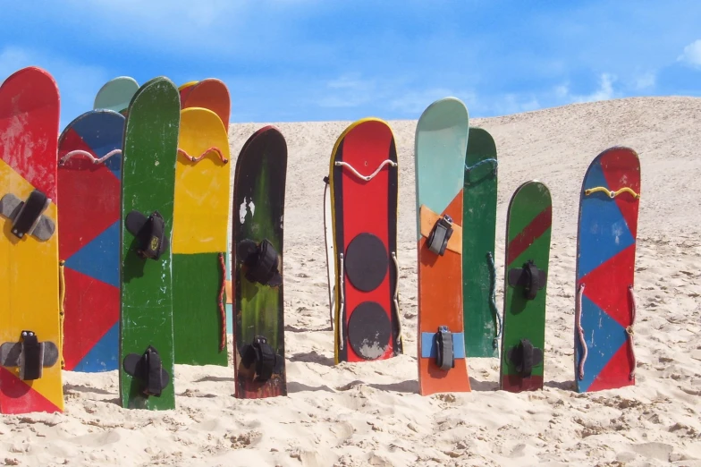 multi colored skis stuck in sand with sky background