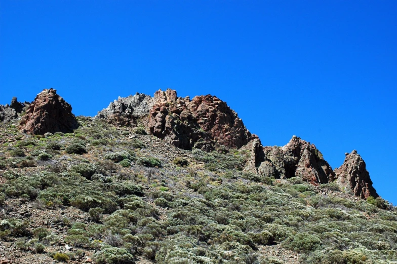 two very rocky mountains against a bright blue sky