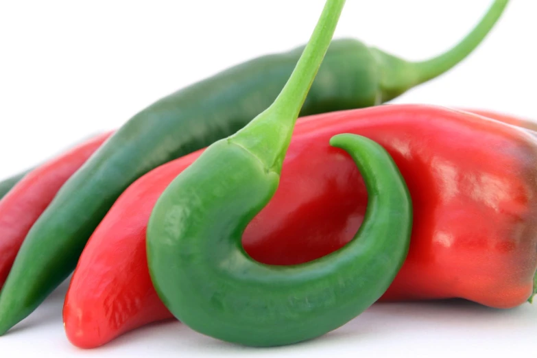 three colorful peppers sitting on top of each other