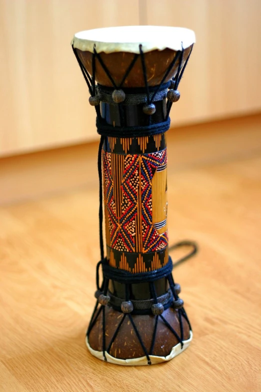 a small african drum sitting on top of a wooden table