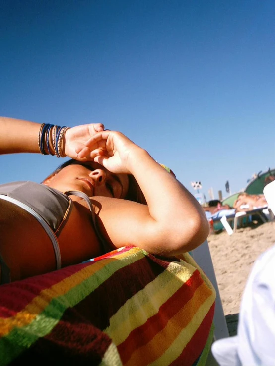 a woman laying on a towel next to a man