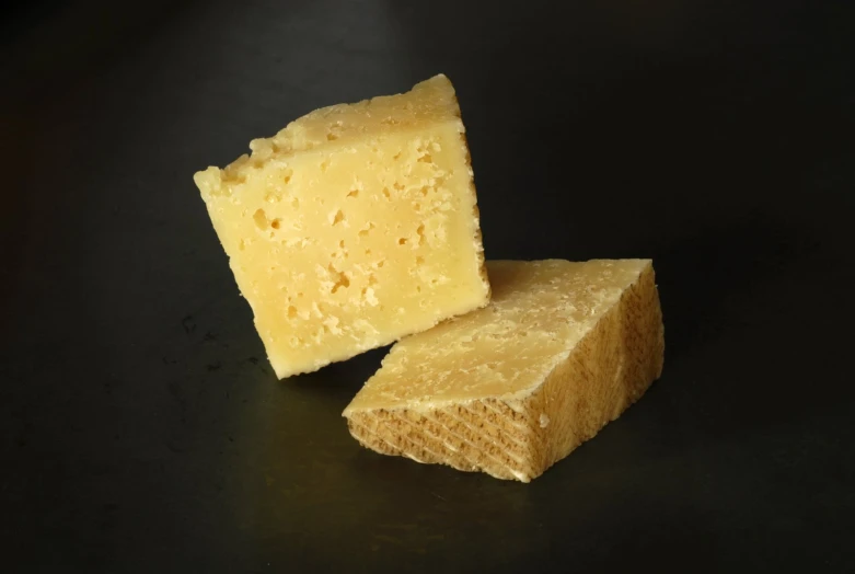 a piece of cheese on a black table