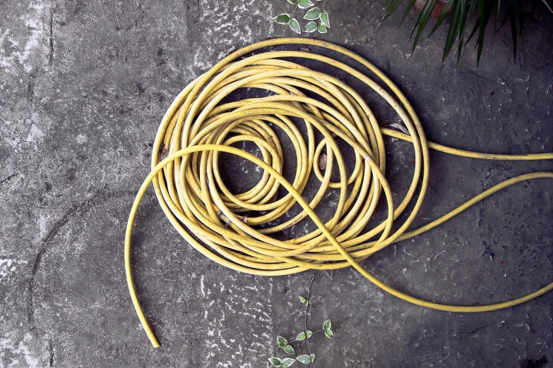 a bunch of long yellow cord on a stone surface