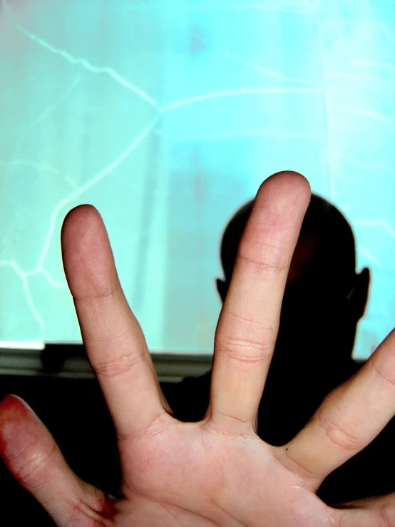 a person's hand reaching up toward a television screen