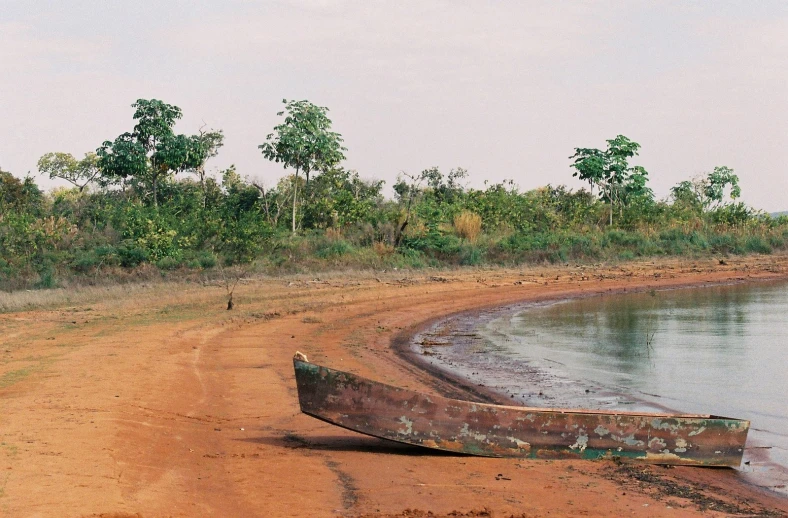 a boat sitting on the shore of a lake