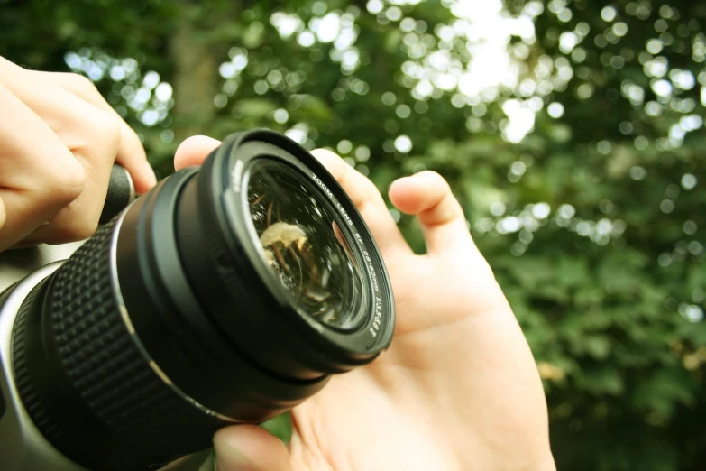 a person is taking a picture with a large lens
