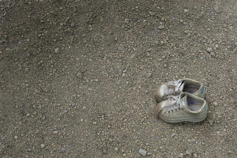 a pair of gray shoes sitting on the ground