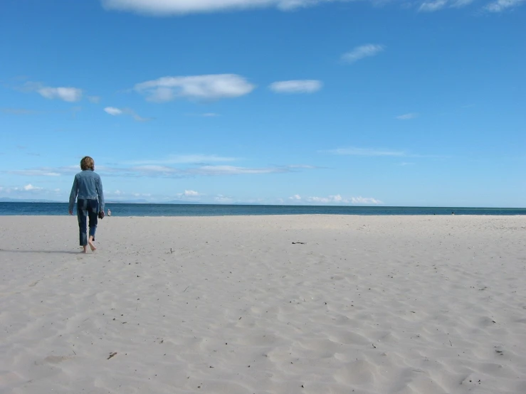 a person is walking alone on the beach