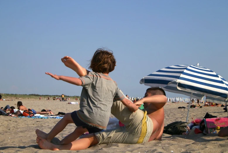 a man sitting on a beach holding up his arms