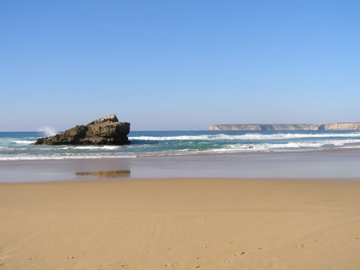 there is a rock in the middle of the beach