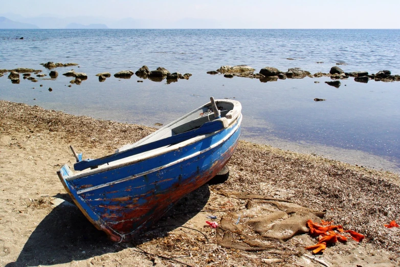 an old boat sitting on the shore at low tide