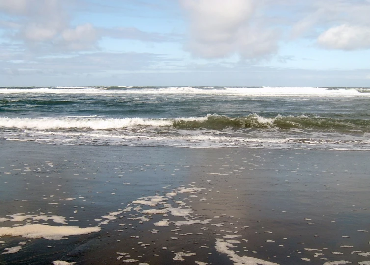 an empty beach and waves are rolling in