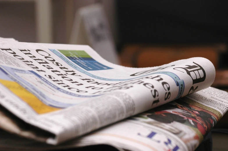 a newspaper sits open on a desk