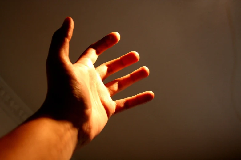 the hand is outstretched towards soing on a gray background
