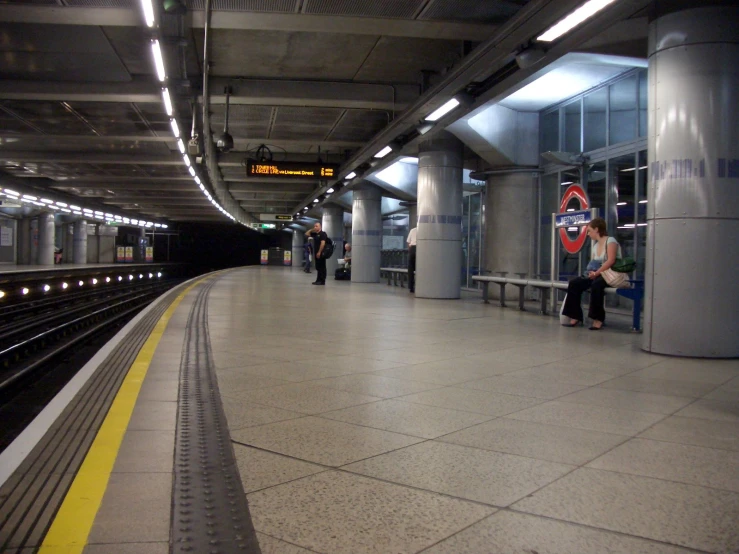 a woman stands at the station waiting for the train