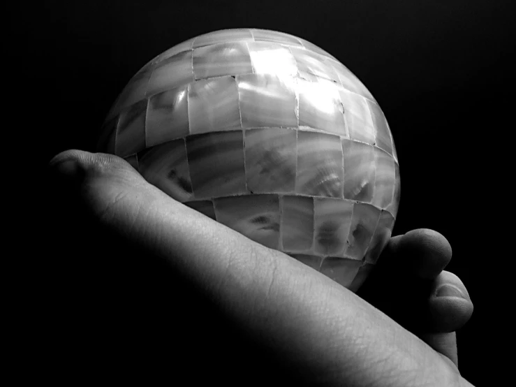 hand holding a sphere ball that has been shaped