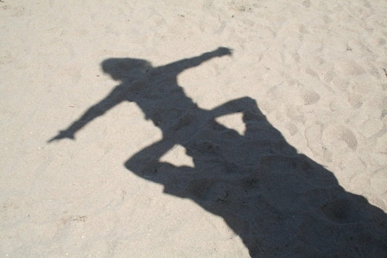 a person casting a shadow on the ground with a skateboard