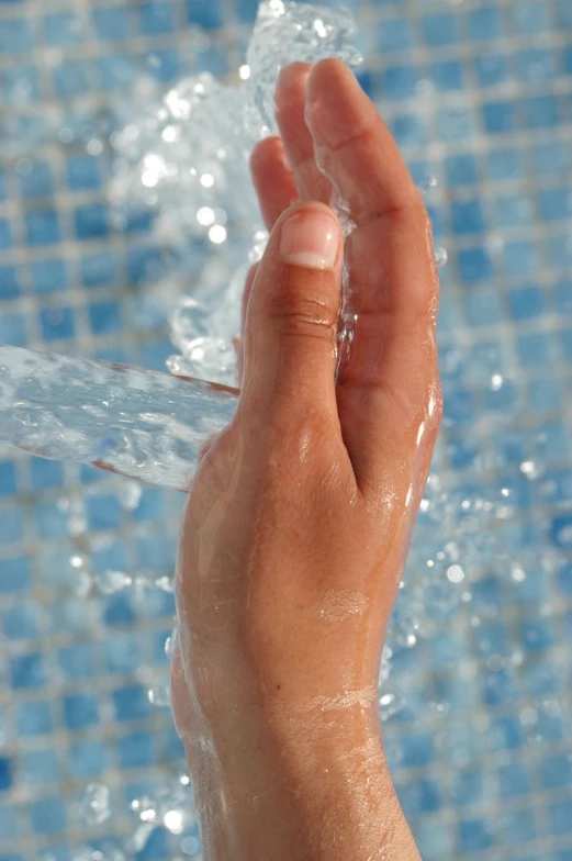 a hand holding an opened piece of plastic near a pool of water
