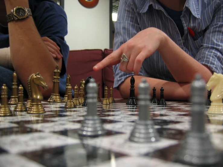 a game of chess with two hands touching it