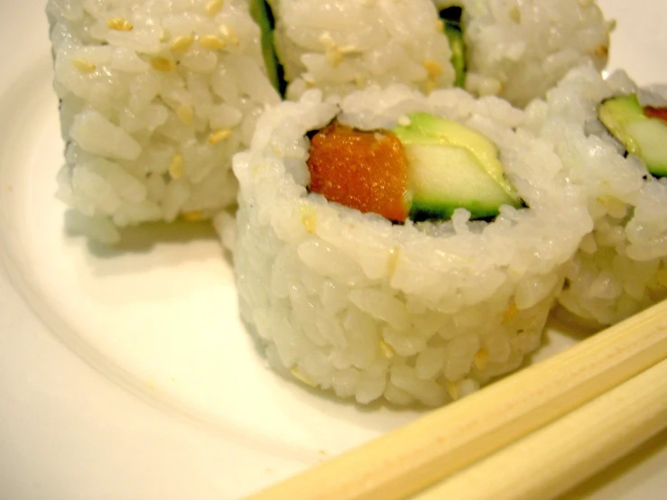 a bunch of food on a plate on top of some wooden chop sticks