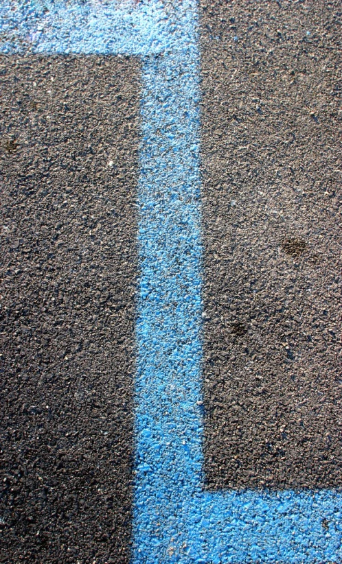 a tennis ball laying on the blue line of the court