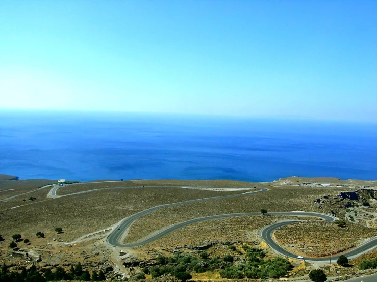 the curved road near the ocean is empty